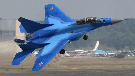A Mikoyan MiG-29K jet fighter in flight, showcasing its striking blue design. This high-definition wallpaper highlights the aircraft's military prowess and sleek profile.
