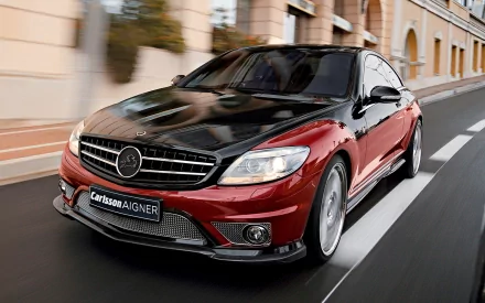 HD PC desktop wallpaper background: glossy red-and-black Mercedes coupe speeding down a city street, close three-quarter front view.