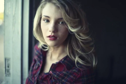 HD desktop wallpaper featuring a woman with long blonde hair and a plaid shirt, captured in soft natural light by Rachel Ann Yampolsky.