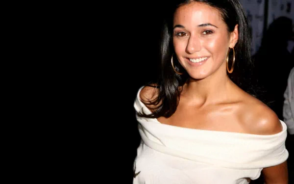 HD PC desktop wallpaper of a smiling female celebrity in an off-the-shoulder white top with gold hoop earrings, posed against a dark background.