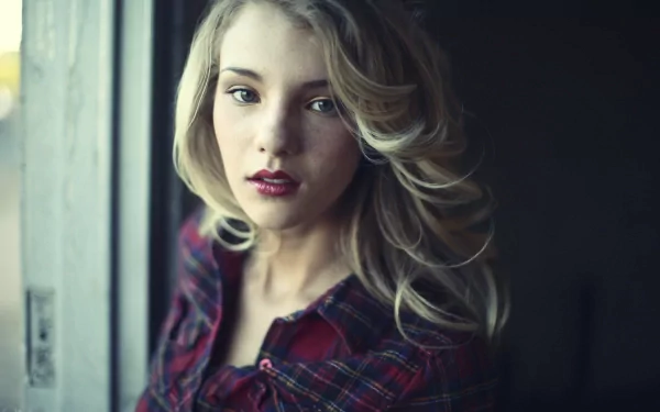 HD desktop wallpaper featuring a woman with long blonde hair and a plaid shirt, captured in soft natural light by Rachel Ann Yampolsky.