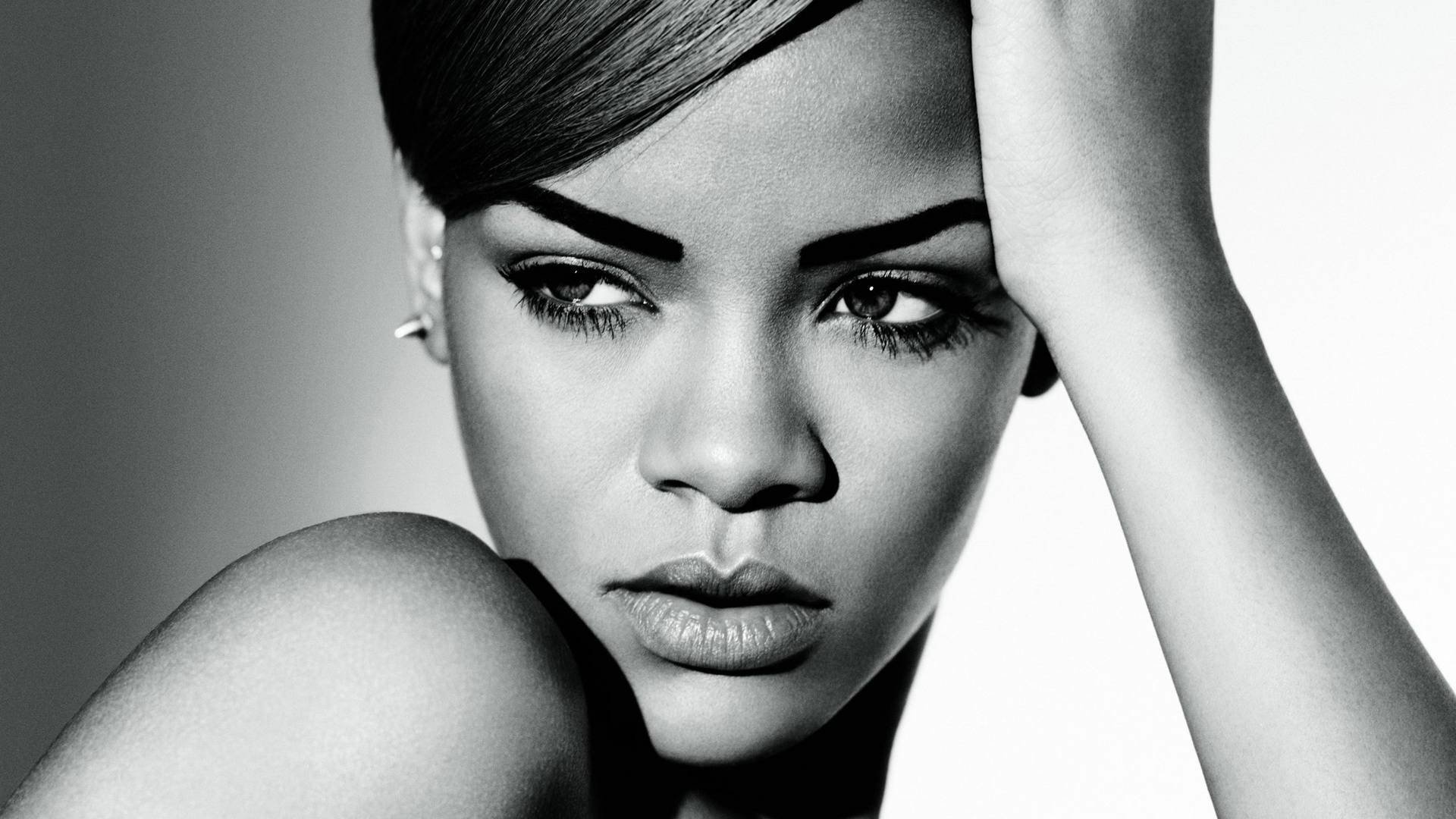 Black and white HD PC desktop wallpaper of Rihanna, showcasing her intense gaze and elegant features in a close-up portrait for a music-themed background.