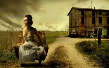 HD desktop wallpaper featuring a woman sitting on a chair in a rural setting, with an old building and dramatic sky in the background.