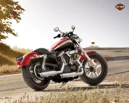 A red Harley-Davidson motorcycle parked on the roadside at sunset, featured as an HD PC desktop wallpaper and background.