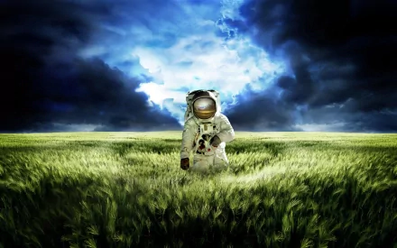An astronaut stands in a vast field under a dramatic sky, blending elements of science fiction with a serene landscape, serving as an inspiring HD desktop wallpaper.