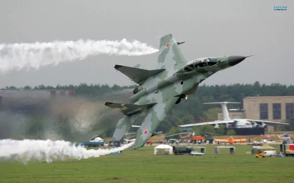 A Mikoyan MiG-29 fighter jet performs a dynamic maneuver, leaving trails of smoke against a backdrop of an airshow, showcasing military aviation prowess. HD desktop wallpaper.