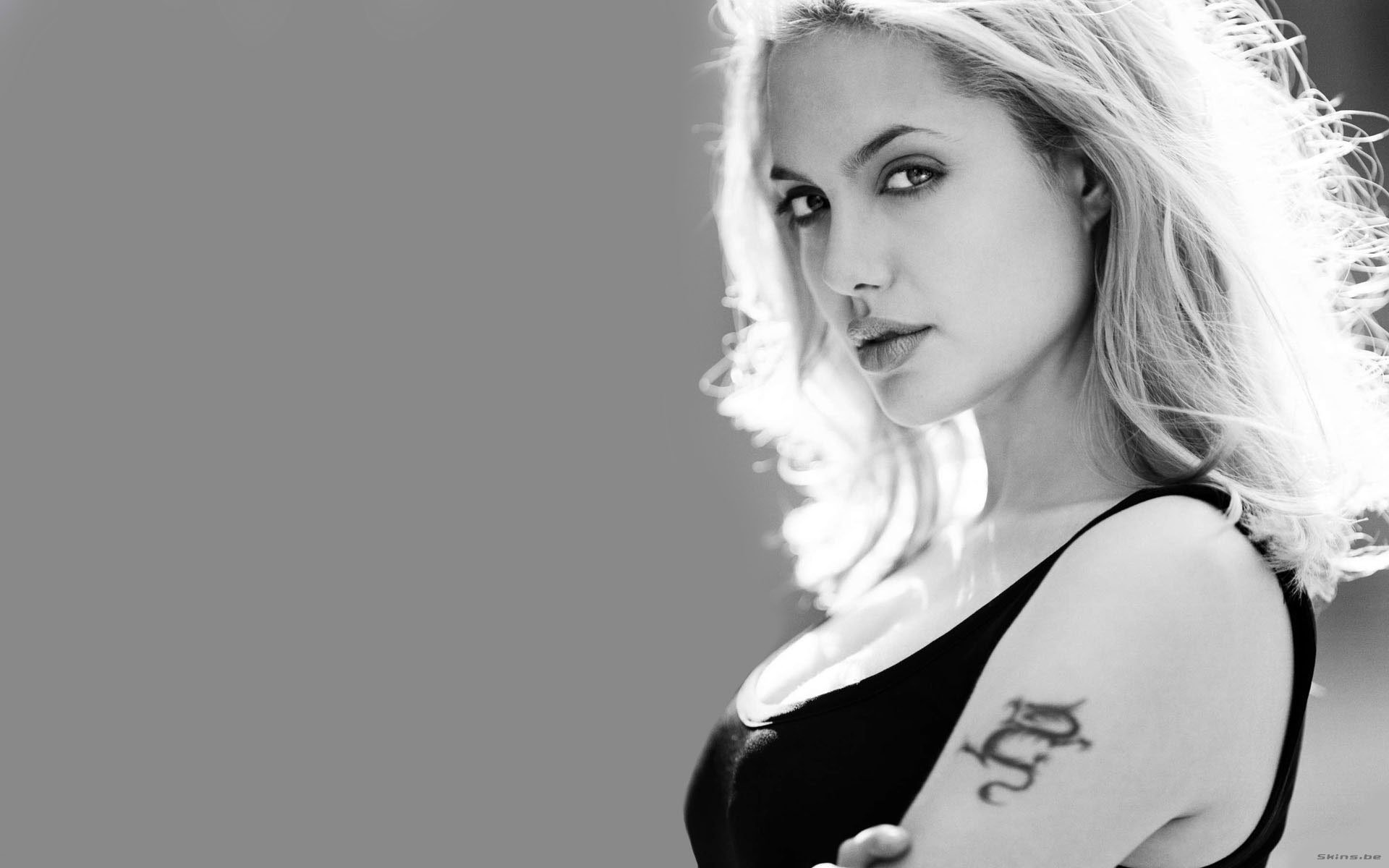 Black and white HD desktop wallpaper featuring Angelina Jolie, showcasing her striking profile and tattoo against a smooth, blurred background.