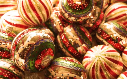 HD Christmas desktop wallpaper featuring a close-up of colorful holiday ornaments with red, green, white, and gold patterns, capturing festive holiday spirit.