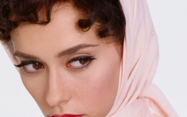 A close-up of Jennifer Love Hewitt, featuring elegant curls and a soft pink scarf, serves as a striking HD wallpaper and background for desktops.