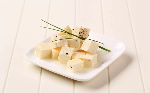 Close-up of cubed white cheese garnished with herbs on a white plate, presented as an HD PC desktop wallpaper background with a clean, minimalist look.