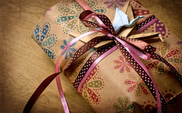 A beautifully wrapped gift with colorful floral patterns and intricate ribbons, providing a warm and inviting atmosphere as a HD PC desktop wallpaper and background.