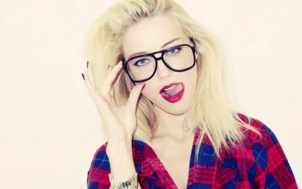 Amber Heard poses playfully in a red checkered shirt and glasses, showcasing her confident style in this high-definition desktop wallpaper.