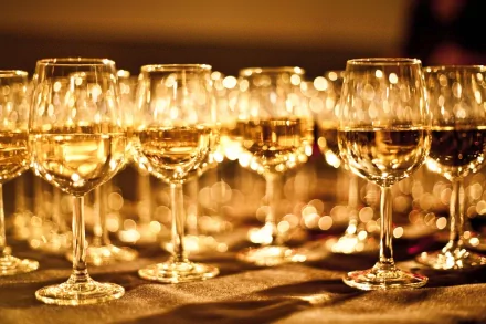 HD photography wallpaper capturing rows of wine glasses reflecting warm, golden light, creating a glowing and elegant ambiance for a PC desktop background.