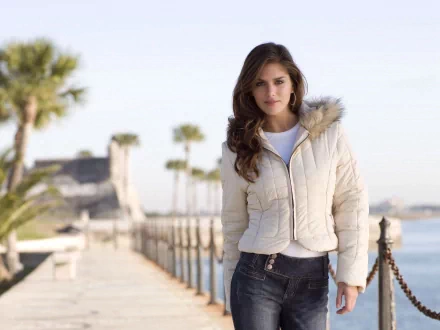 HD PC desktop wallpaper featuring Anahi Gonzales standing on a sunny boardwalk with palm trees and ocean in the background.