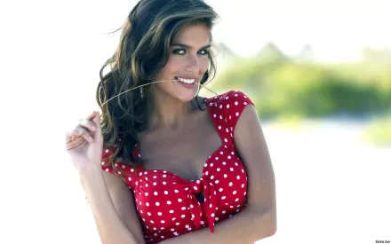HD desktop wallpaper featuring a smiling woman in a red polka dot dress with long hair, tagged with Anahi Gonzales.