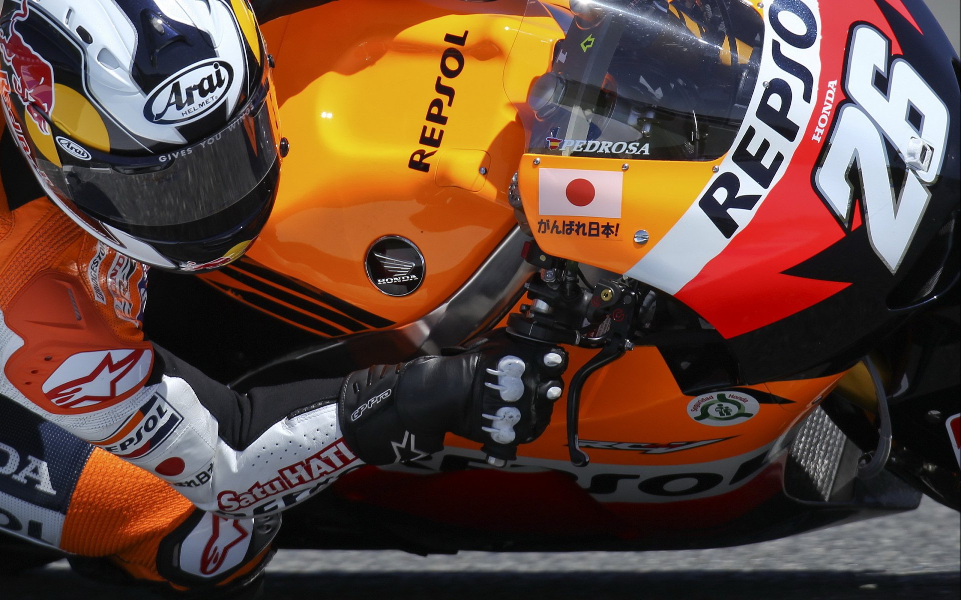 HD desktop wallpaper featuring a close-up of a Honda Repsol racing motorcycle and rider in full gear during a race.