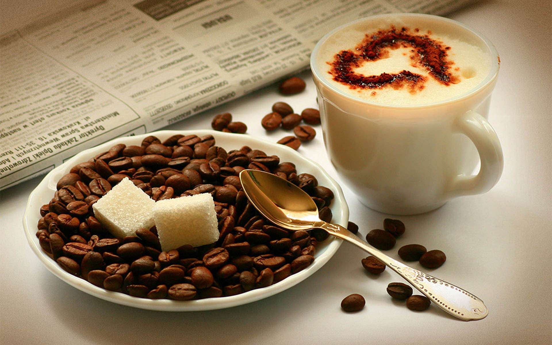 HD desktop wallpaper showing a cup of coffee with frothy heart design, a plate filled with coffee beans and sugar cubes, and a newspaper in the background.