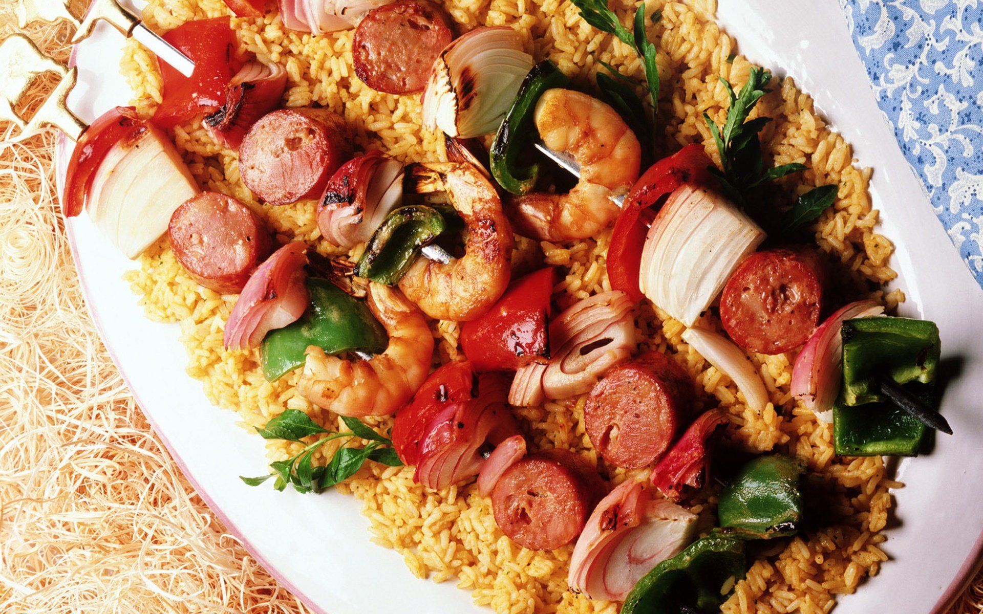 HD PC desktop wallpaper featuring a vibrant meal of shrimp, sausage, and vegetables served over seasoned rice on a white platter.