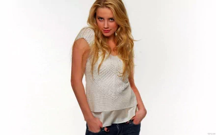 HD wallpaper featuring Amber Heard, showcasing her playful expression in a casual outfit with wavy blonde hair. A striking background adds to the visual appeal.
