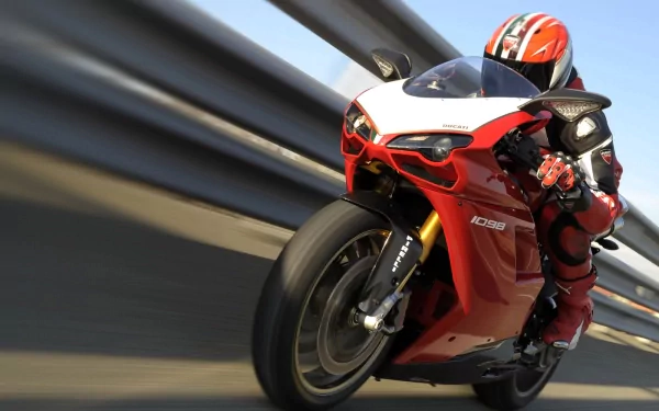 HD PC desktop wallpaper of a red Ducati sportbike with rider leaning into a turn, motion-blurred guardrail background.