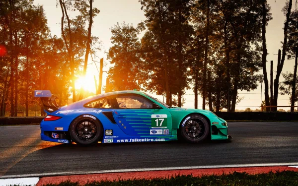 HD PC desktop wallpaper of a blue-green Porsche race car (#17) on a sunlit racetrack at sunset, with trees silhouetted against golden light.