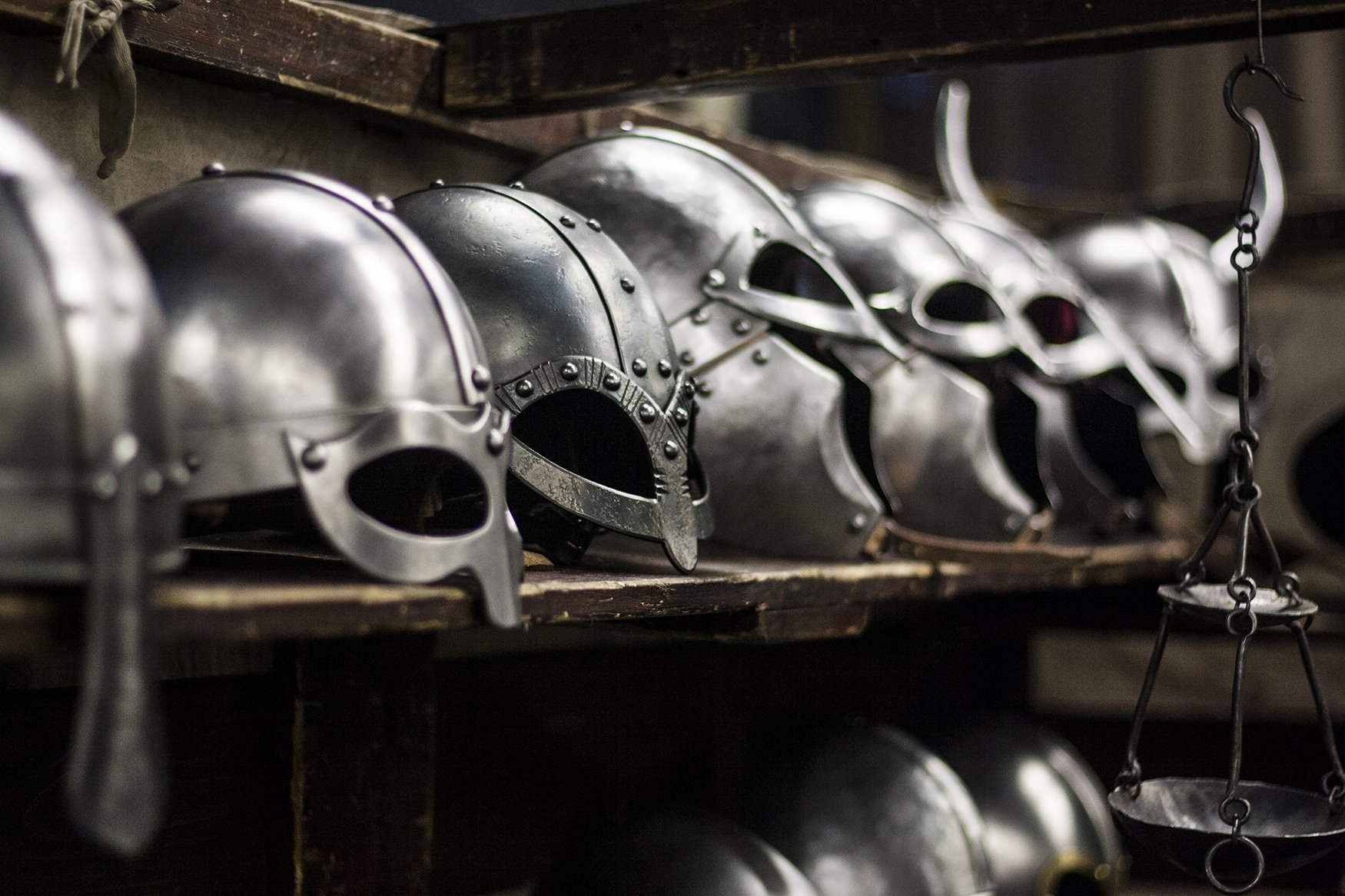 HD PC desktop wallpaper and background: man-made polished metal helmets lined on wooden shelves, medieval-style designs with reflective surfaces.