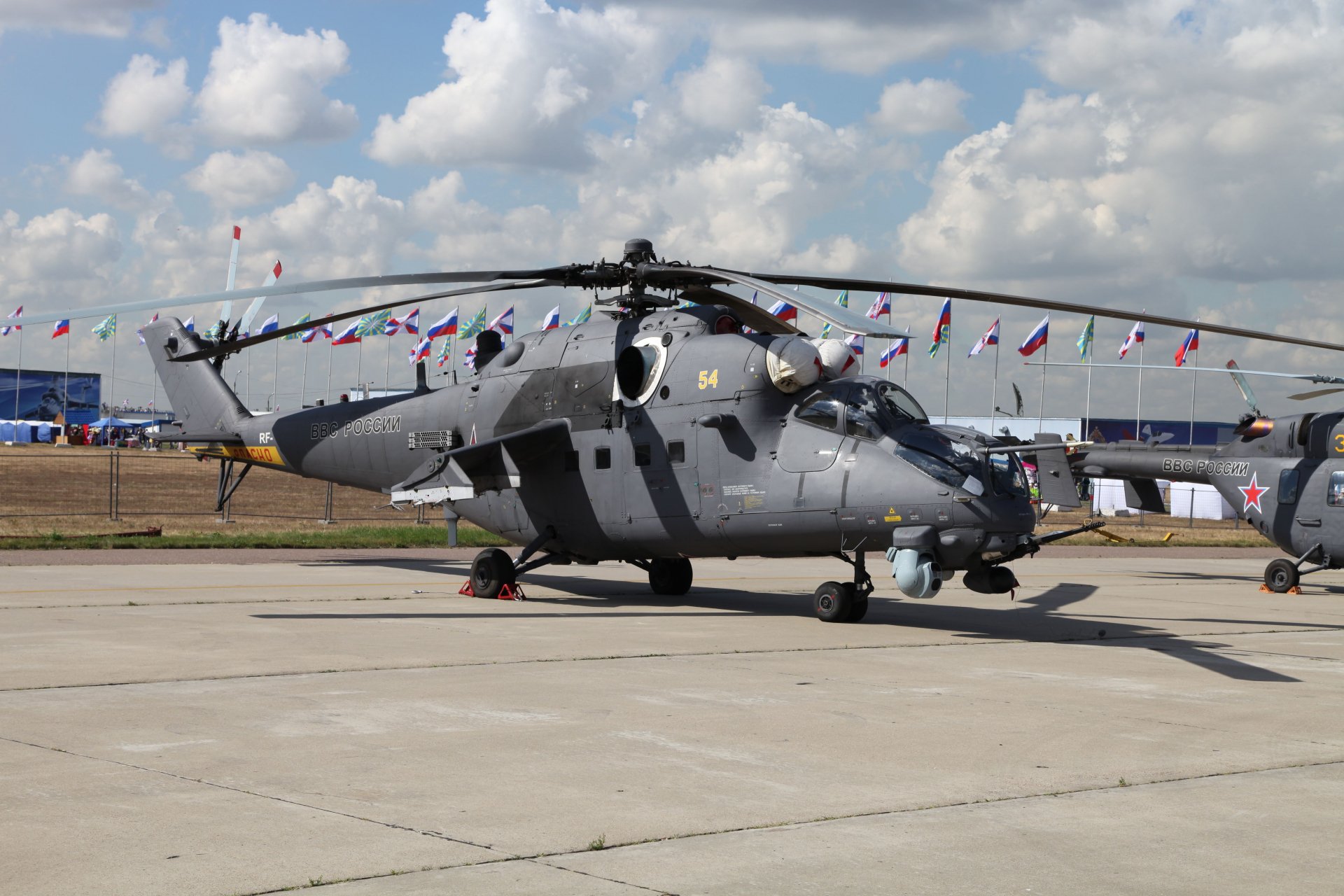 A Mil Mi-35 military helicopter parked on a tarmac under a partly cloudy sky, captured in 4K Ultra HD for a PC desktop wallpaper.