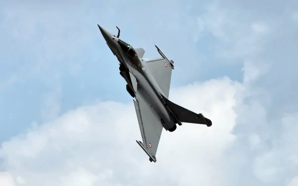 HD PC desktop wallpaper background featuring a military Dassault Rafale fighter jet banking sharply against a cloudy sky.