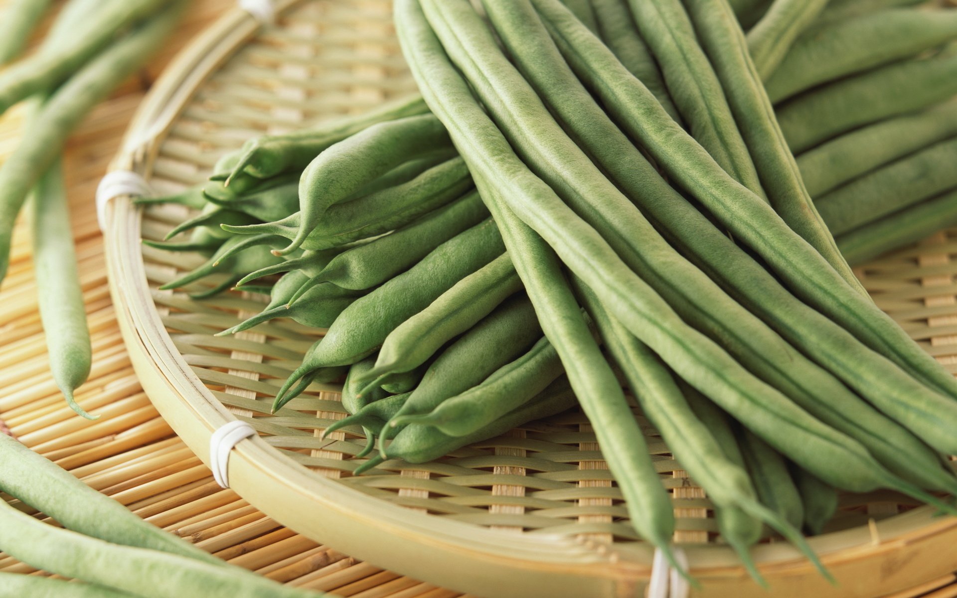 Close-up of fresh green beans arranged on a woven bamboo tray, captured in high definition for a vibrant PC desktop wallpaper background.