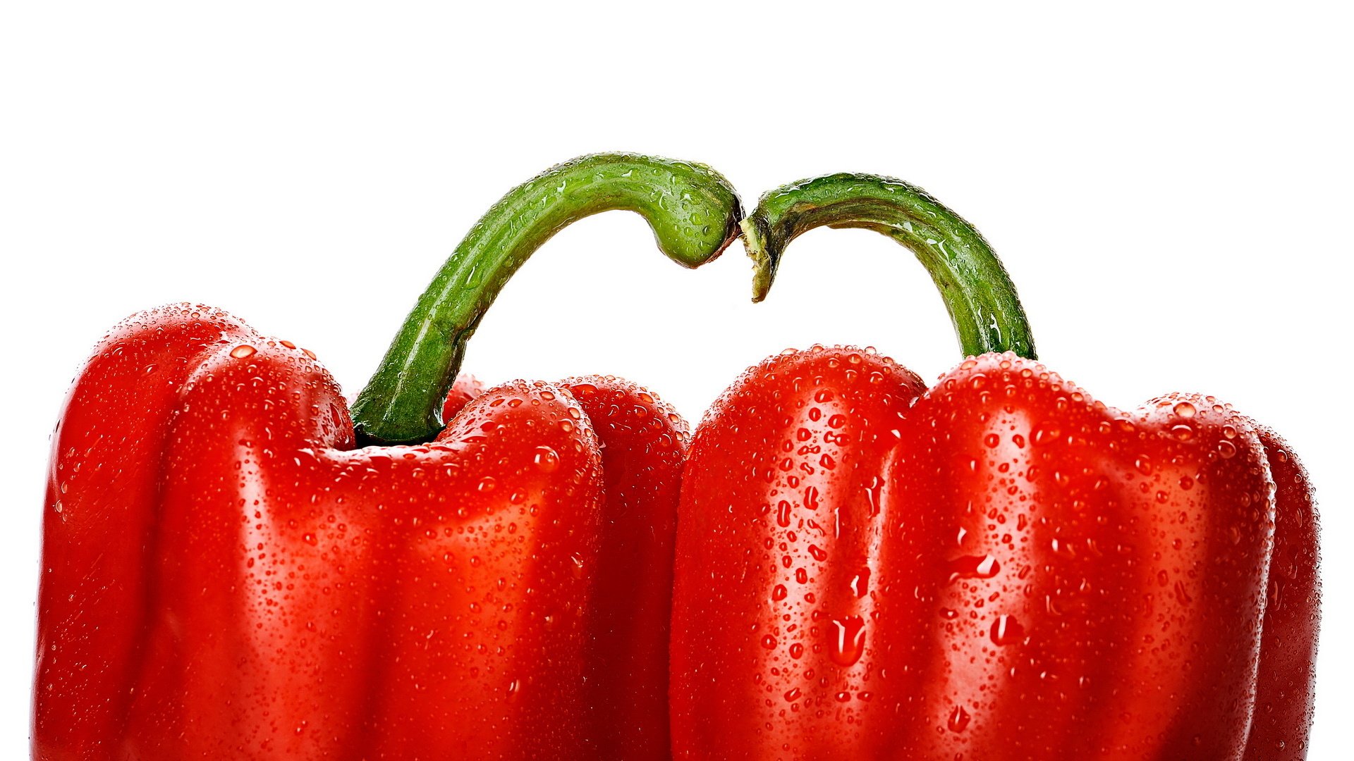 HD desktop wallpaper of two fresh red peppers with water droplets on their surfaces, set against a clean white background.
