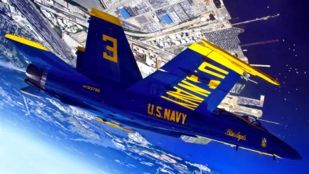 A blue U.S. Navy McDonnell Douglas F/A-18 Hornet from the Blue Angels performs a military air show maneuver over a coastal city in this HD desktop wallpaper.