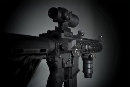 Close-up of a sophisticated assault rifle, featuring a sleek design and mounted scope, set against a dark background, serving as a striking HD PC desktop wallpaper.