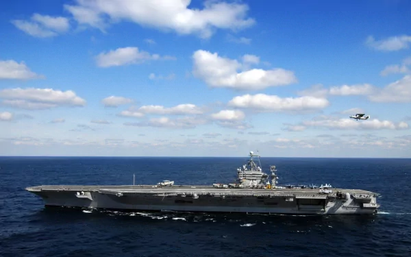 HD desktop wallpaper featuring the USS Harry S. Truman (CVN-75) aircraft carrier sailing on a clear day with a small plane flying nearby over the ocean.