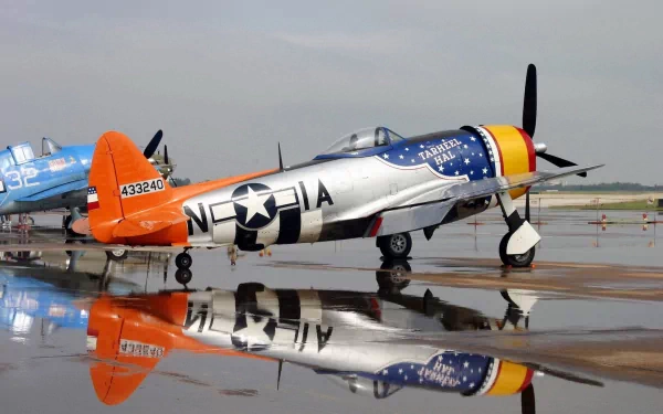 HD desktop wallpaper featuring a vintage military aircraft with polished silver body, patriotic star insignia, and vibrant orange tail reflected on a wet runway.