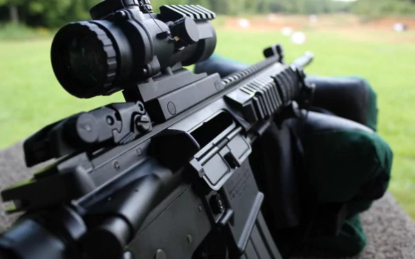 Close-up of a black assault rifle with a scope, set against an outdoor backdrop, designed as a 4K Ultra HD PC desktop wallpaper and background.