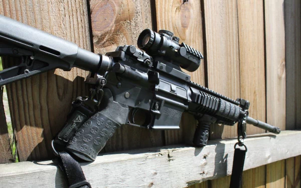 5K Ultra HD PC desktop wallpaper of a man-made assault rifle resting on a wooden fence, close-up showing stock, rail, optic and barrel.