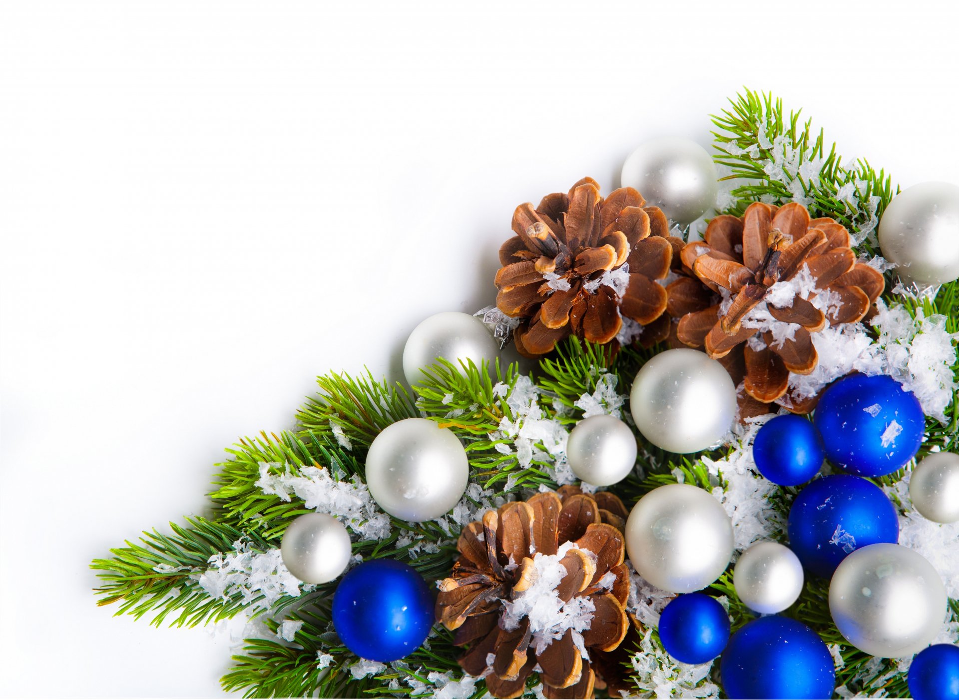 Christmas ornaments including blue and silver baubles, snow-dusted pine cones, and evergreen branches arranged on a white background in 8K Ultra HD quality.