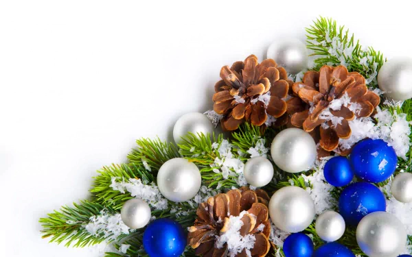 Christmas ornaments including blue and silver baubles, snow-dusted pine cones, and evergreen branches arranged on a white background in 8K Ultra HD quality.