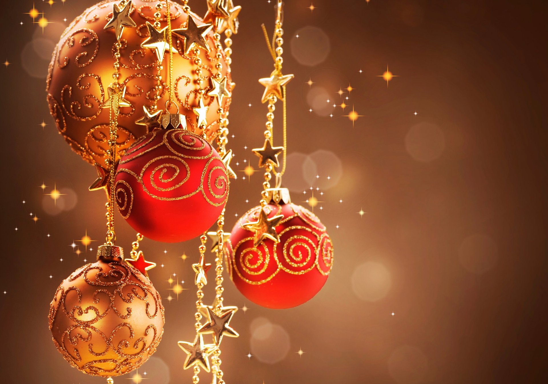 A vibrant display of Christmas ornaments in gold and red, adorned with swirls and star accents, creating a festive atmosphere against a warm, shimmering background. 4K Ultra HD.