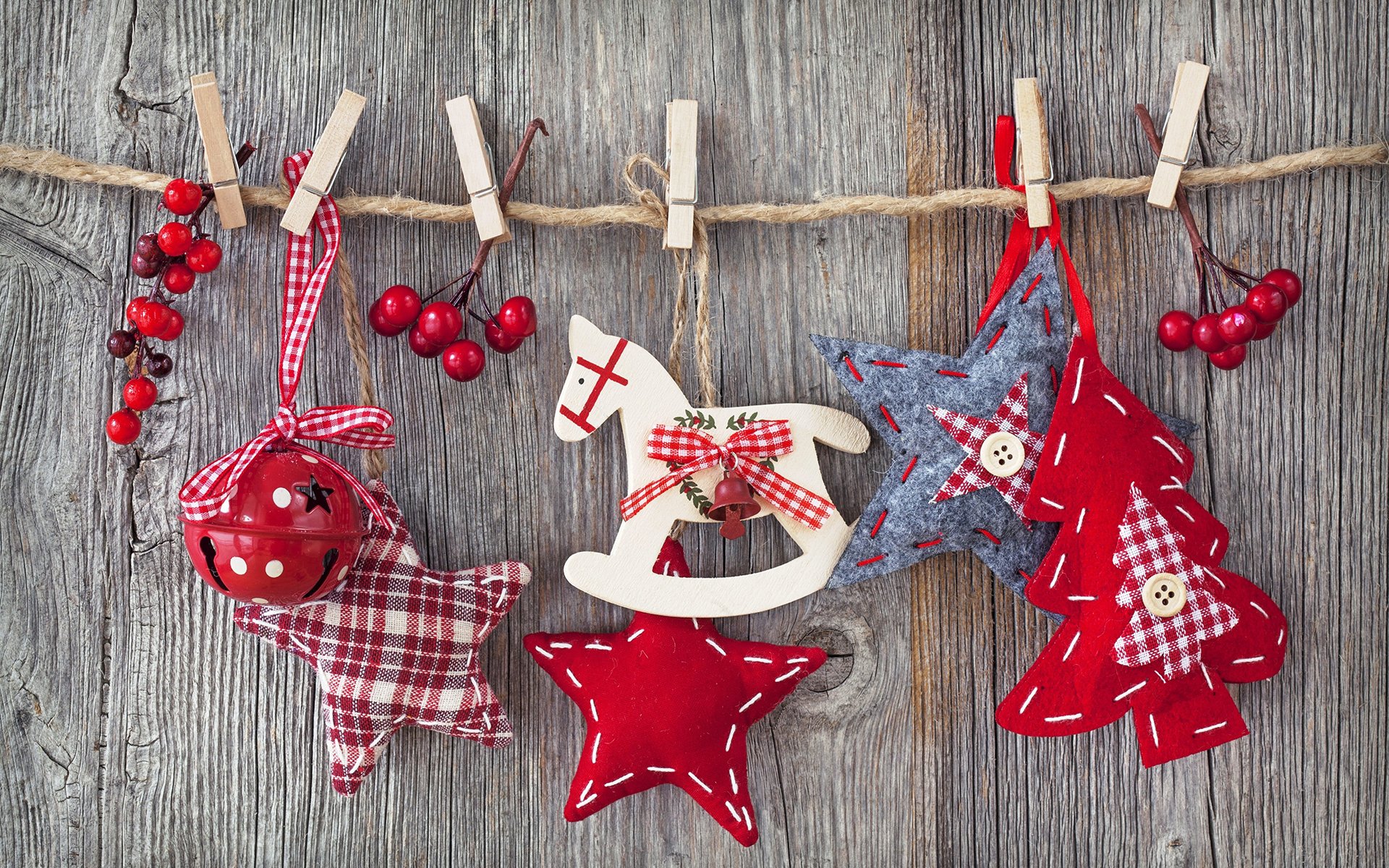 A charming display of Christmas ornaments, including stars, a rocking horse, and festive colors, hung on a rustic wooden background, creating a joyful holiday atmosphere.