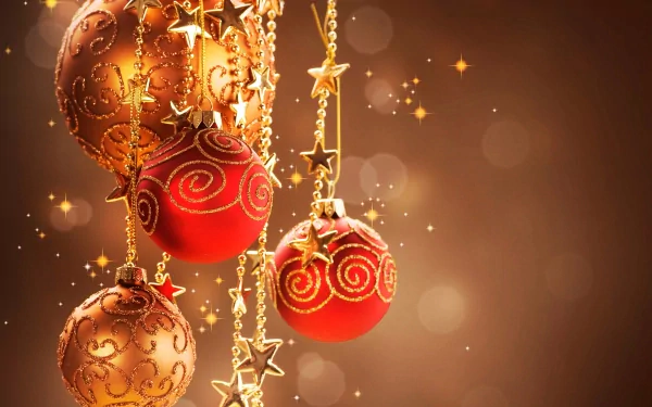 A vibrant display of Christmas ornaments in gold and red, adorned with swirls and star accents, creating a festive atmosphere against a warm, shimmering background. 4K Ultra HD.