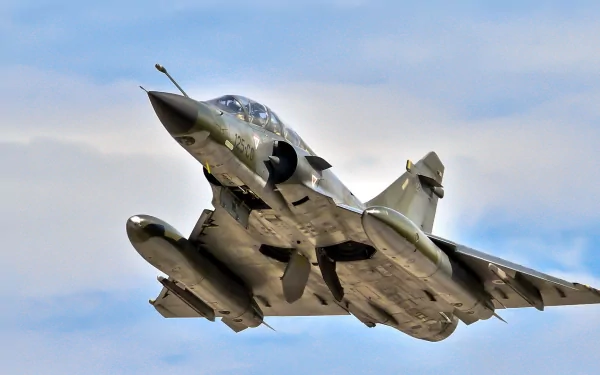 HD military desktop wallpaper featuring a Dassault Mirage 2000 jet fighter captured mid-flight against a partly cloudy sky.