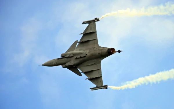 A military Saab JAS 39 Gripen fighter jet soars against a blue sky, captured in high definition for a striking desktop wallpaper background.