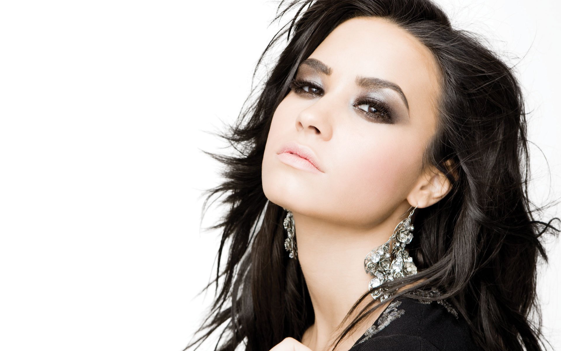 HD desktop wallpaper featuring Demi Lovato with smoky eye makeup and statement earrings, reflecting her music persona.