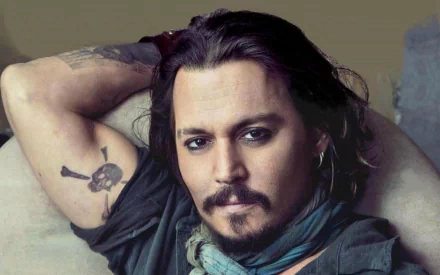 HD desktop wallpaper featuring celebrity Johnny Depp, showcasing him in a relaxed pose with one arm behind his head, revealing a tattoo.