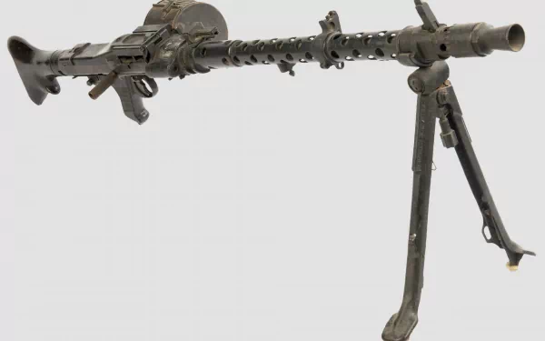 A detailed image of a machine gun set against a minimalist background, showcasing its man-made design. This high-definition wallpaper highlights the weapon's intricate features.