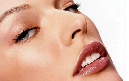 Close-up portrait of Milla Jovovich showcasing her striking features, with a smooth complexion and captivating gaze, designed as a high-definition desktop wallpaper.