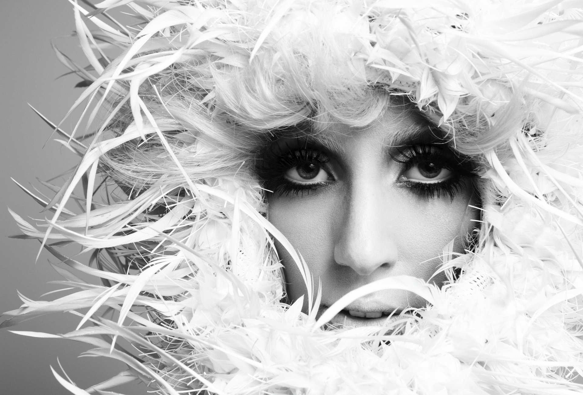 A black and white image of Lady Gaga, featuring her striking eyes framed by a dramatic feathered hairstyle, creating a captivating and artistic visual. 4K Ultra HD quality.