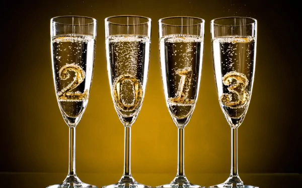 A festive HD wallpaper showcasing champagne glasses filled with bubbly, featuring the year 2013 in gold, celebrating the New Year with elegance and cheer.