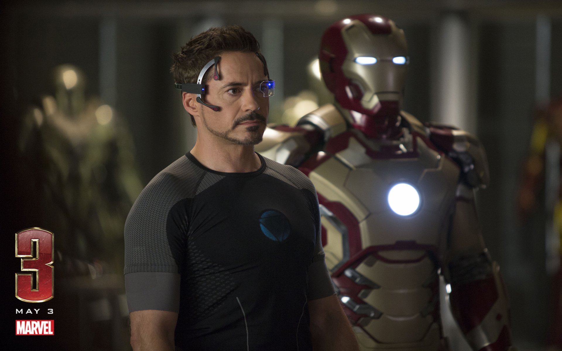 HD desktop wallpaper from Iron Man 3 featuring Tony Stark in a tech suit with Iron Man armor in the background. Marvel logo and release date May 3 are displayed in the bottom left corner.